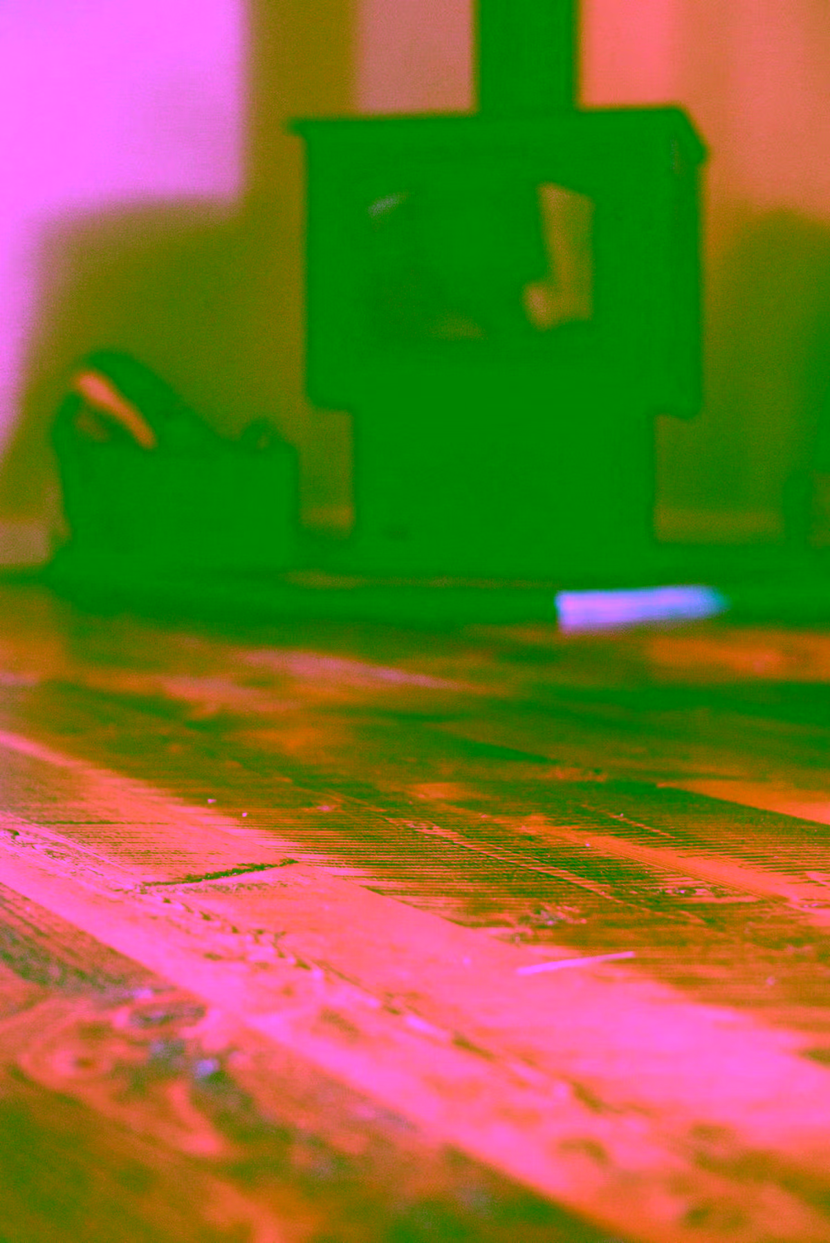 Floor-level shot with a wood stove and warm amber hardwood floors